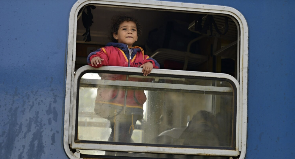 Ukrainian refugee child looking out of the window of a train
